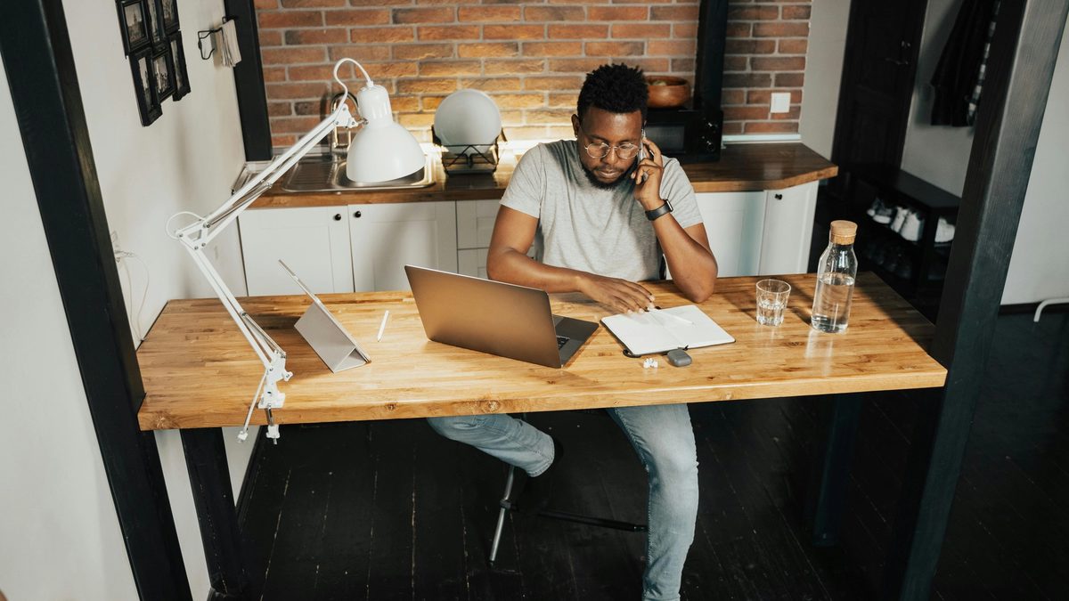 Person sitting at a desk while on the phone and looking at notes
