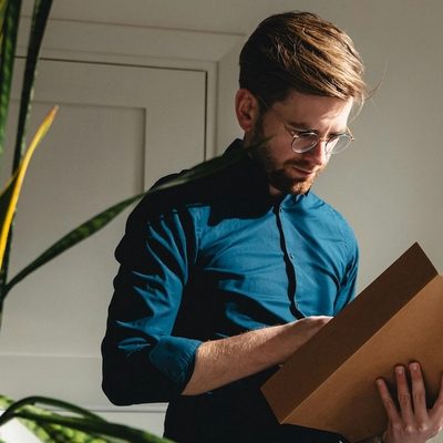 a male therapist organizes files in his sunny, plant-filled office