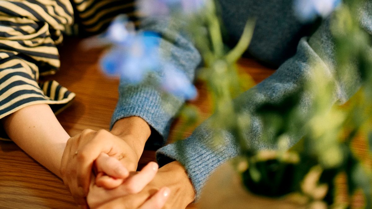a close up of two people hold hands