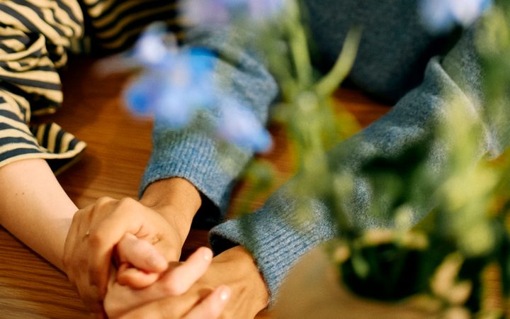 a close up of two people hold hands