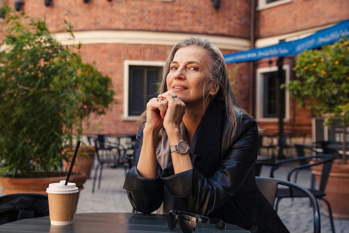 a woman sits outside of a university, considering if she should become a counselor as a second career