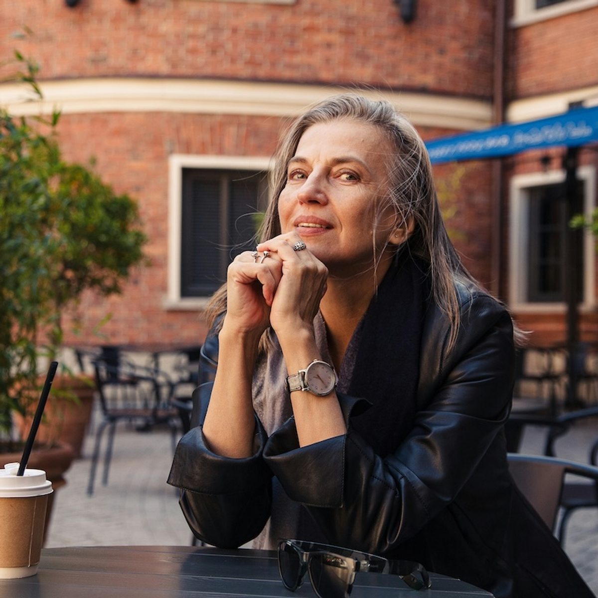 a woman sits outside of a university, considering if she should become a counselor as a second career