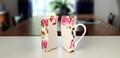 A porcelain mug with a floral print, evenly cleaved in two.
