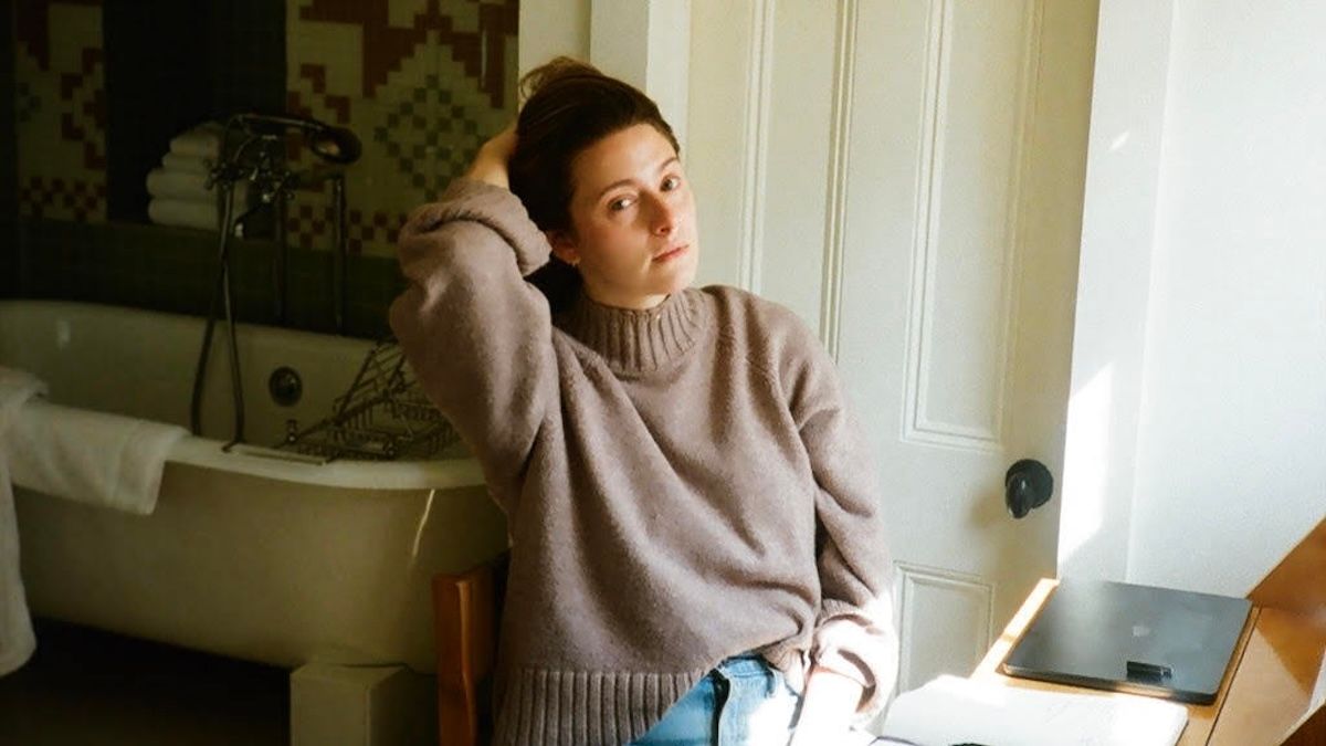 Bisexual author and playwright Haley Jakobson sits at her writing desk in Brooklyn, NY.