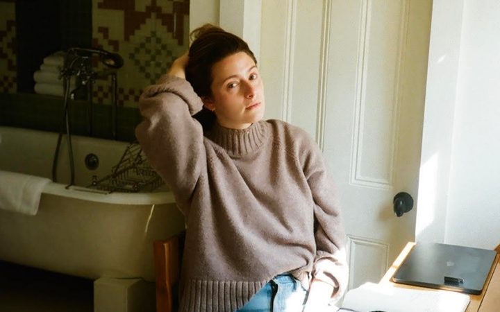 Bisexual author and playwright Haley Jakobson sits at her writing desk in Brooklyn, NY.