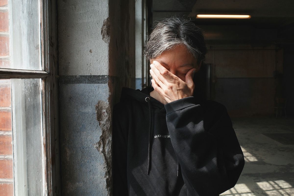 A woman experiencing a mental health crisis stands by a window
