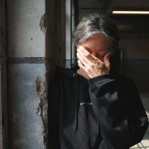 A woman experiencing a mental health crisis stands by a window