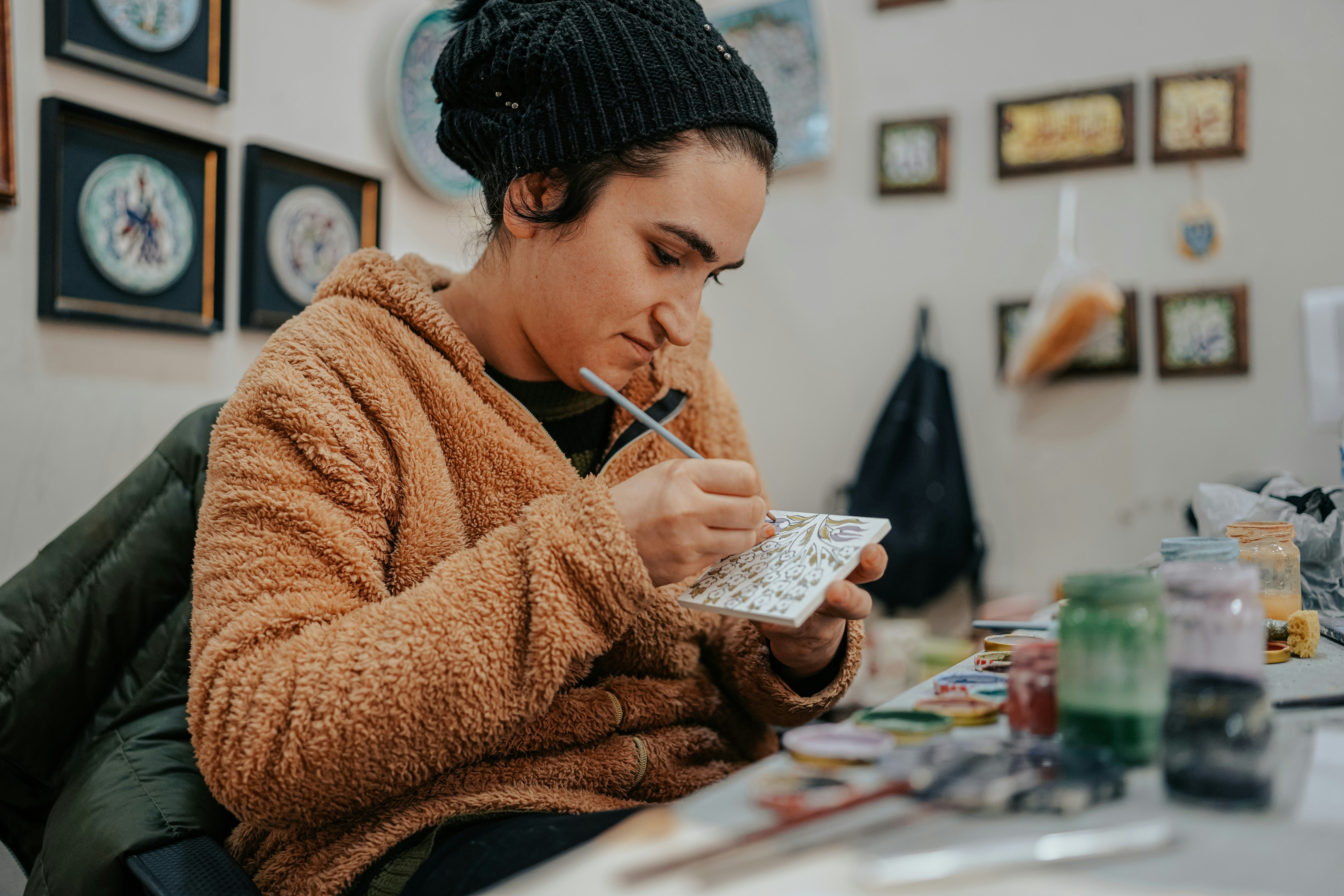 art therapist painting a cermanic tile