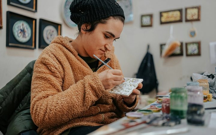 art therapist painting a cermanic tile