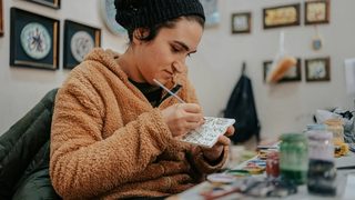 art therapist painting a cermanic tile