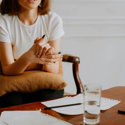 Man sitting on an orange couch speaking with a therapist who is taking notes