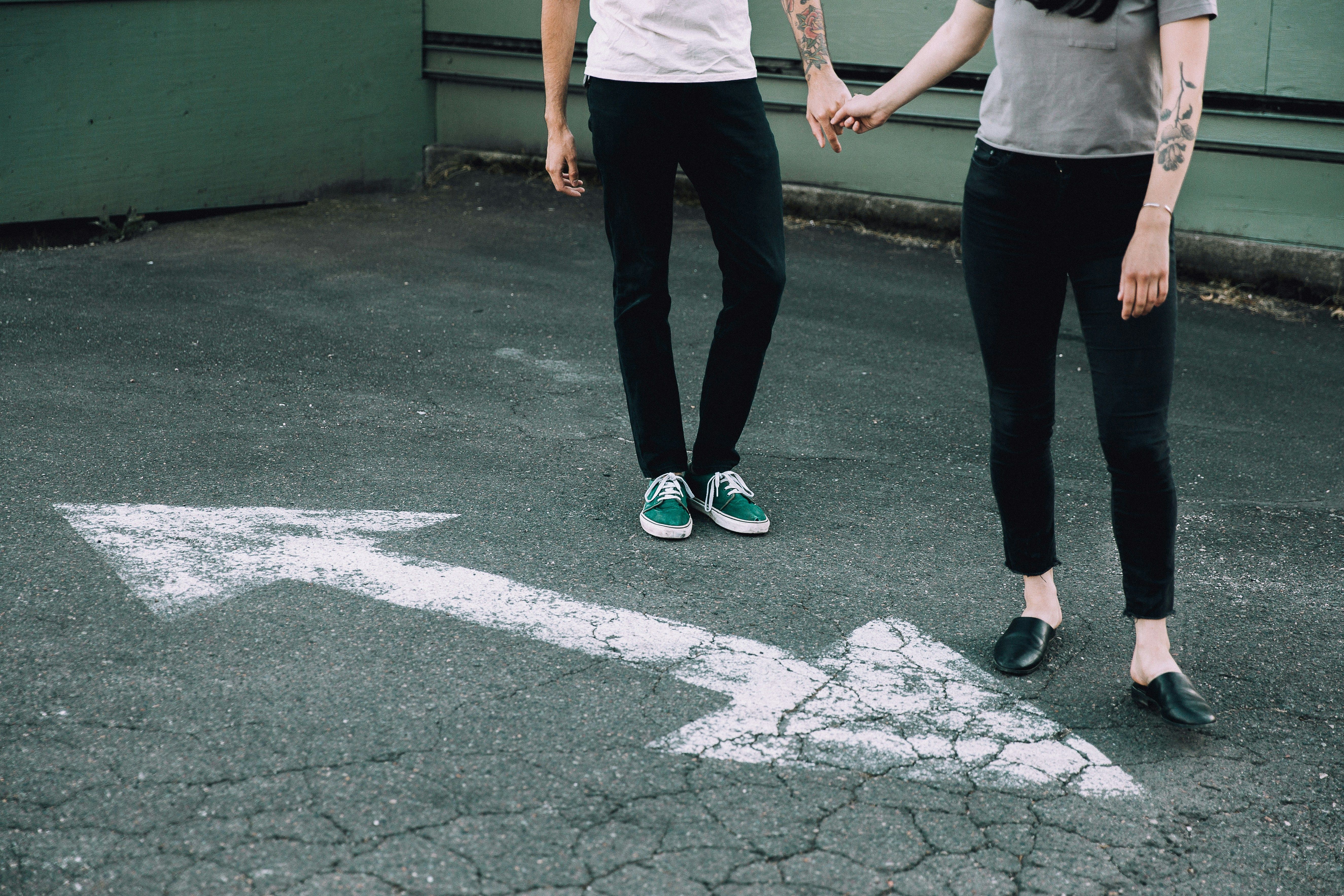 Man and woman holding hands on a blacktop street.