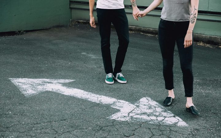 Man and woman holding hands on a blacktop street.
