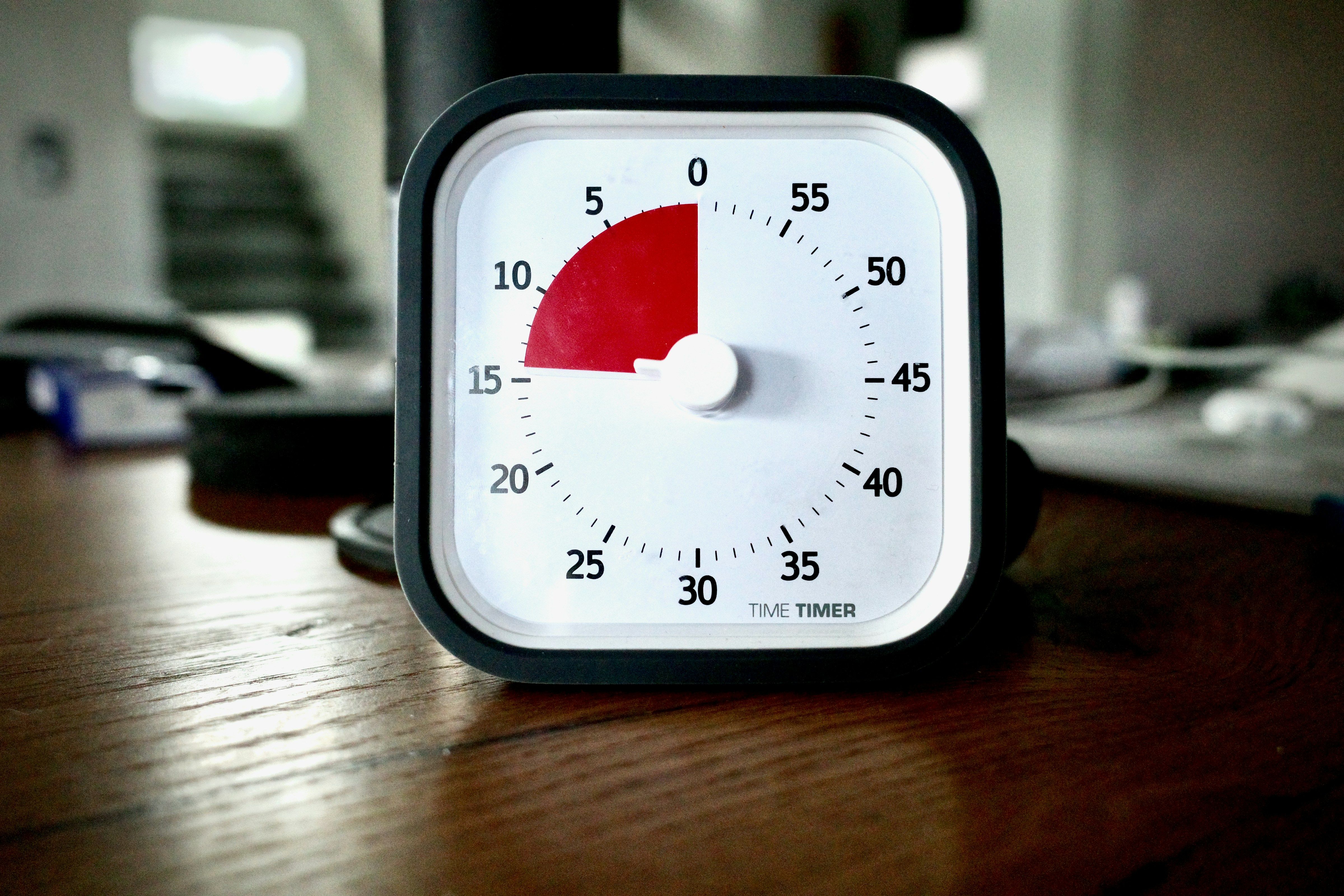 15 minute timer sitting on top of a wooden desk