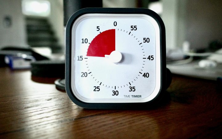 15 minute timer sitting on top of a wooden desk