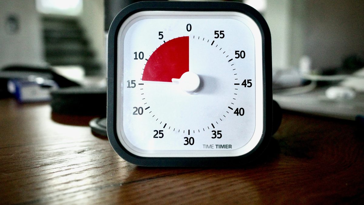 15 minute timer sitting on top of a wooden desk