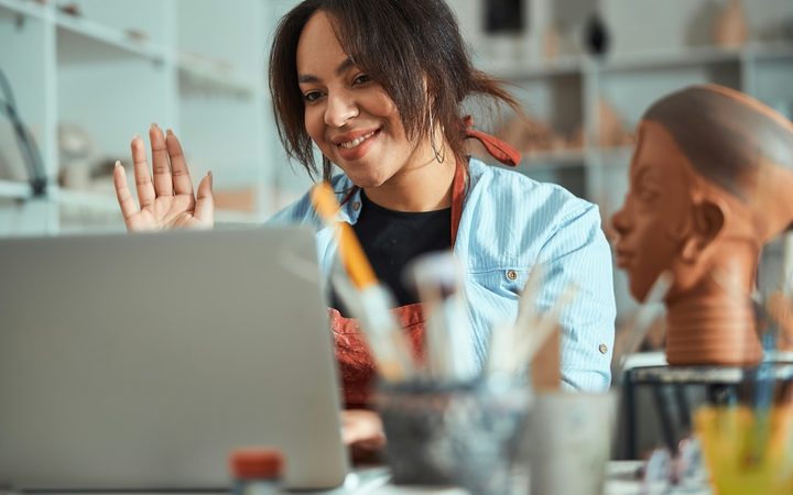 A art therapist waves hello to a client at the start of an online art therapy session.