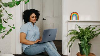woman sitting on the floor with her laptop opened on her lap