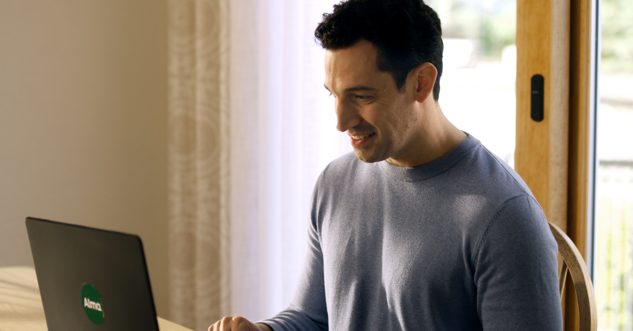 Man in blue shirt in front of laptop