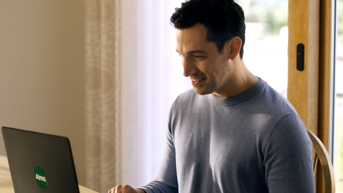 Man in blue shirt in front of laptop