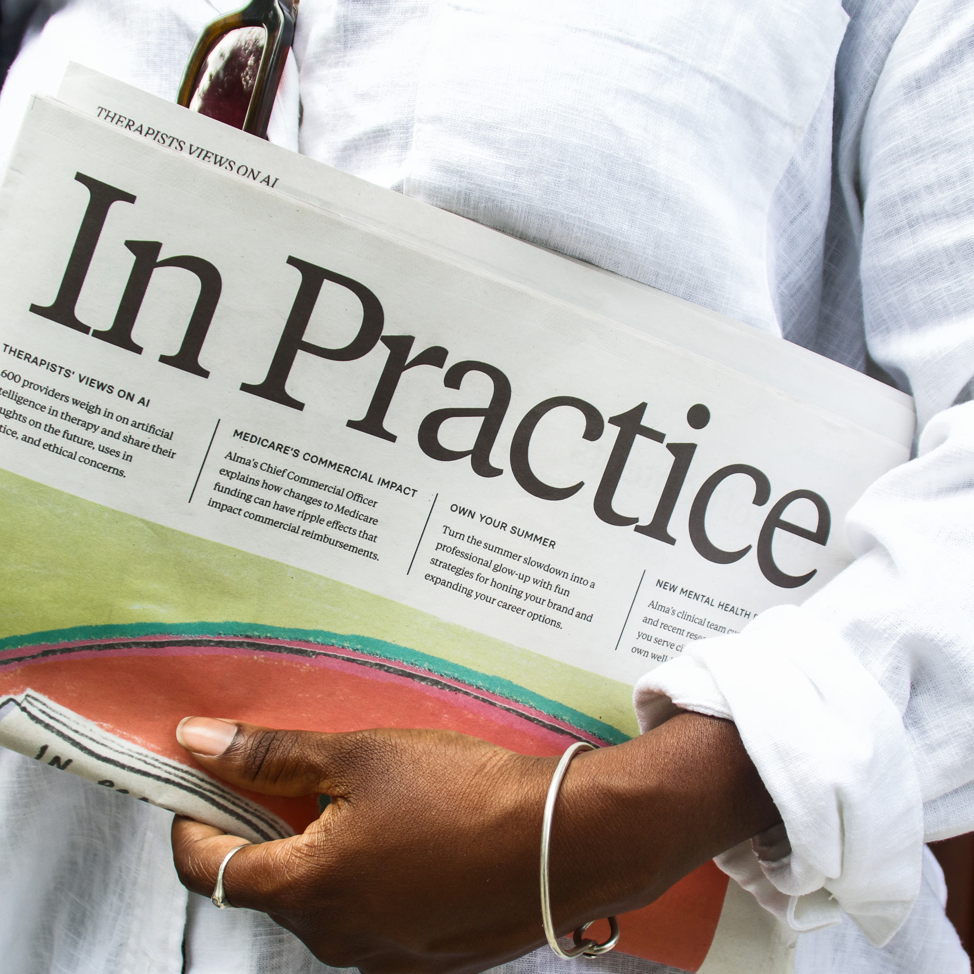 woman holding a copy of the In Practice newspaper