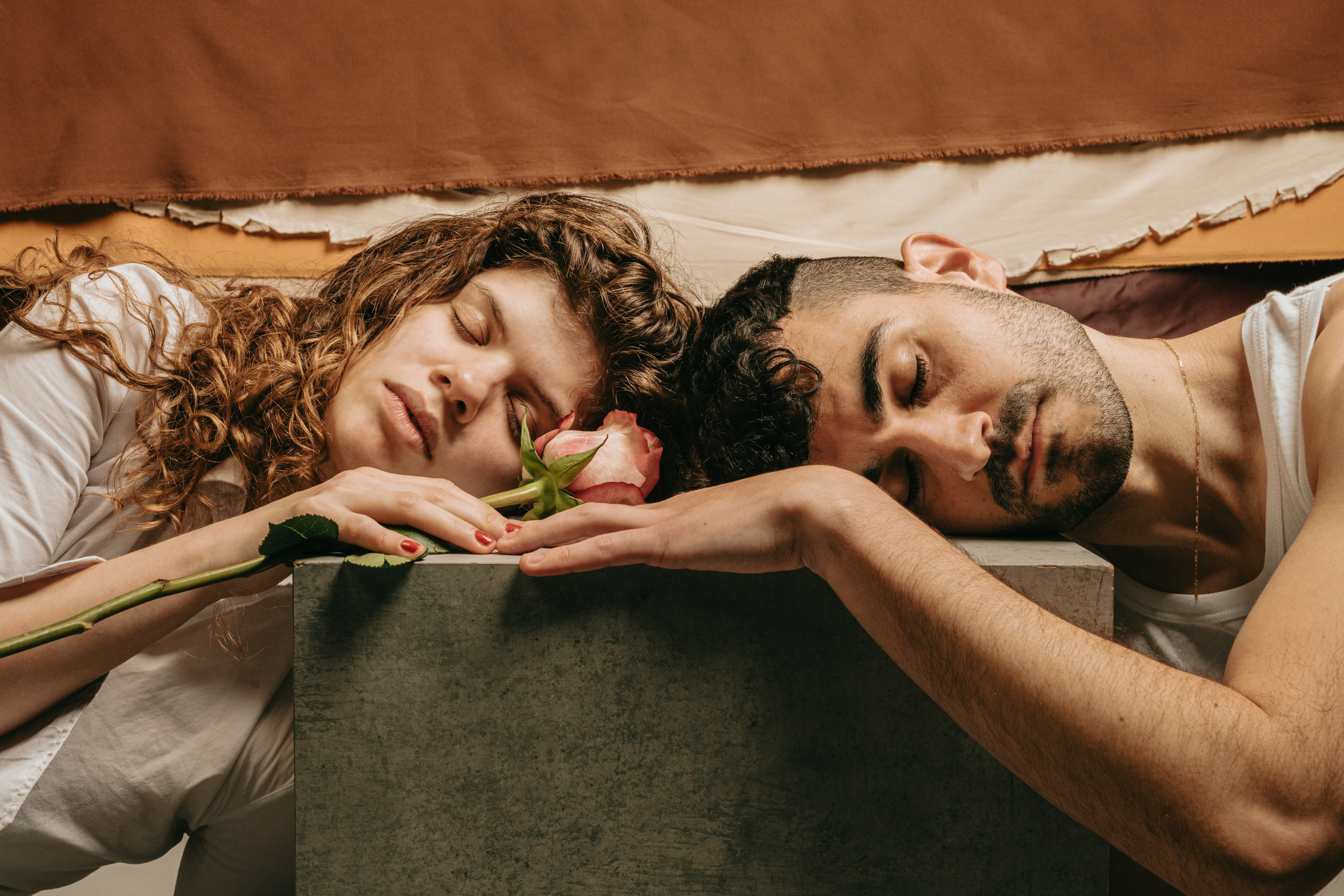 A couple resting on a block with a pink rose