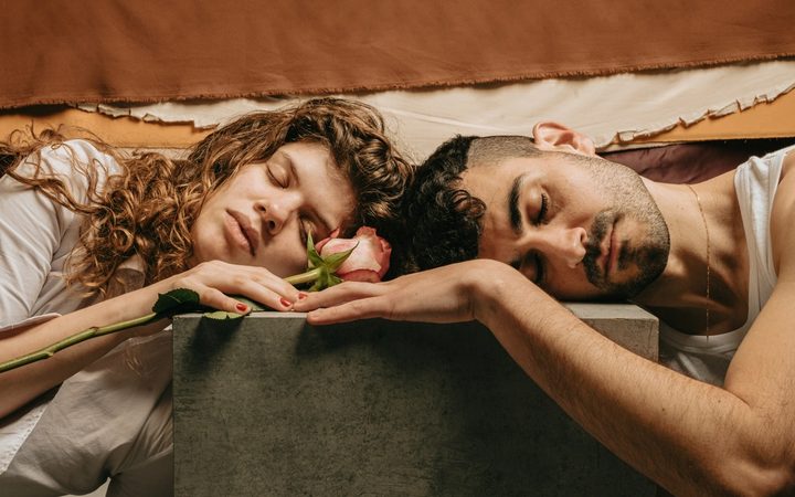 A couple resting on a block with a pink rose