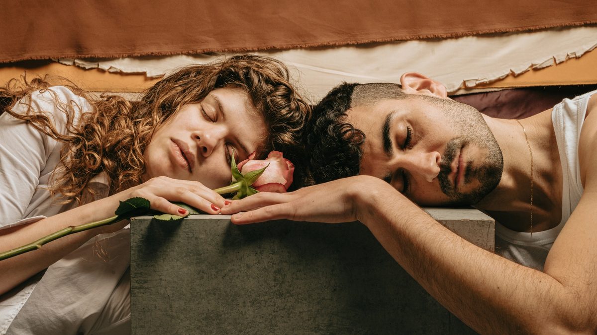 A couple resting on a block with a pink rose