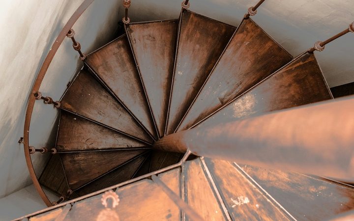 a downward view of an old wooden spiral staircase to represent dorsal vagal shutdown
