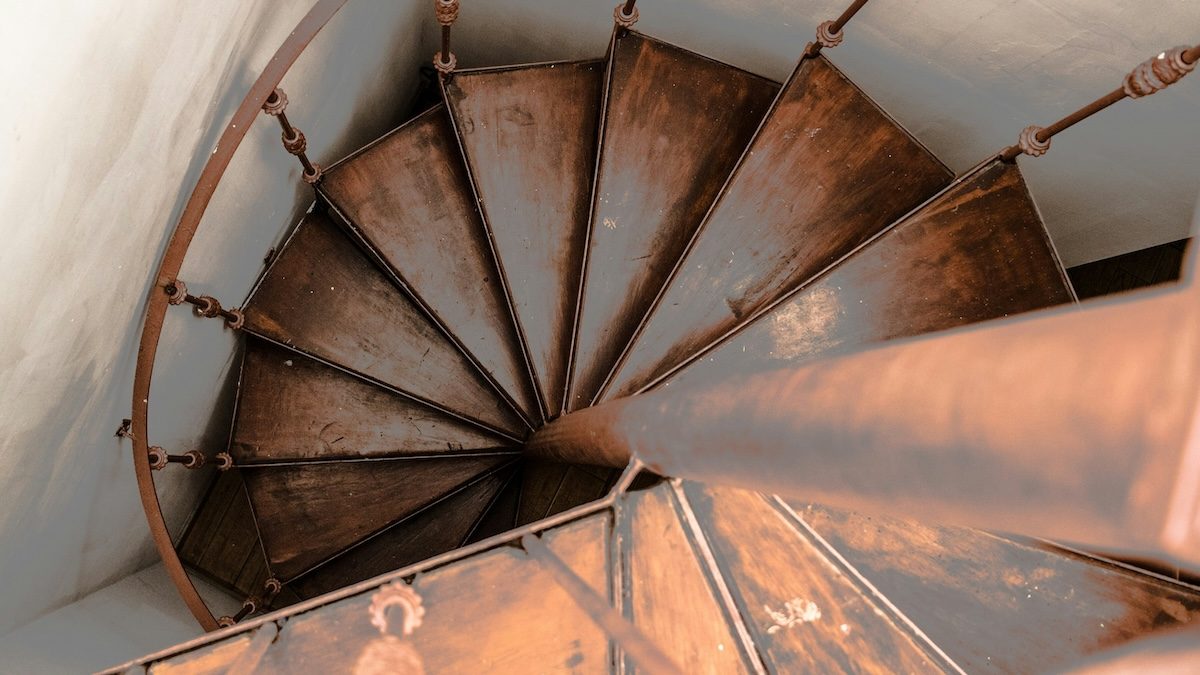 a downward view of an old wooden spiral staircase to represent dorsal vagal shutdown