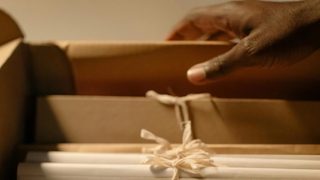 a hand lifting a file folder out of a drawer