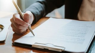 A close-up of a mental health therapist using a checklist of therapist credentialing requirements