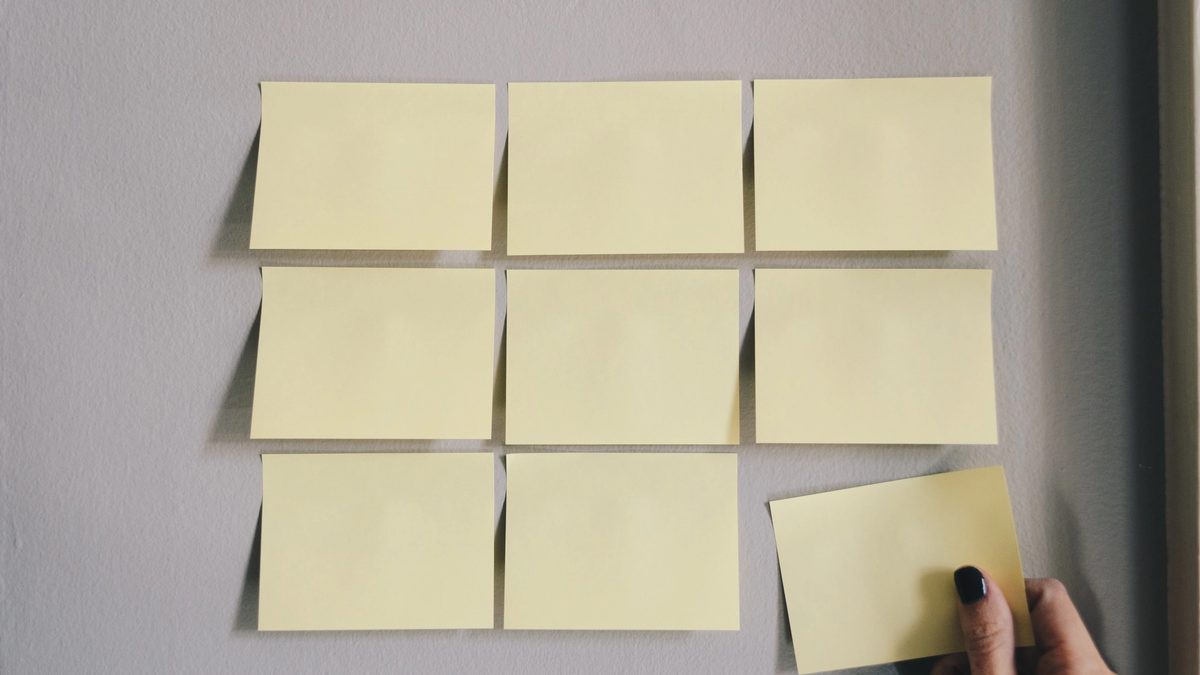 A person places sticky notes on their wall to visualize and plan their work as a coping strategy for ADHD.