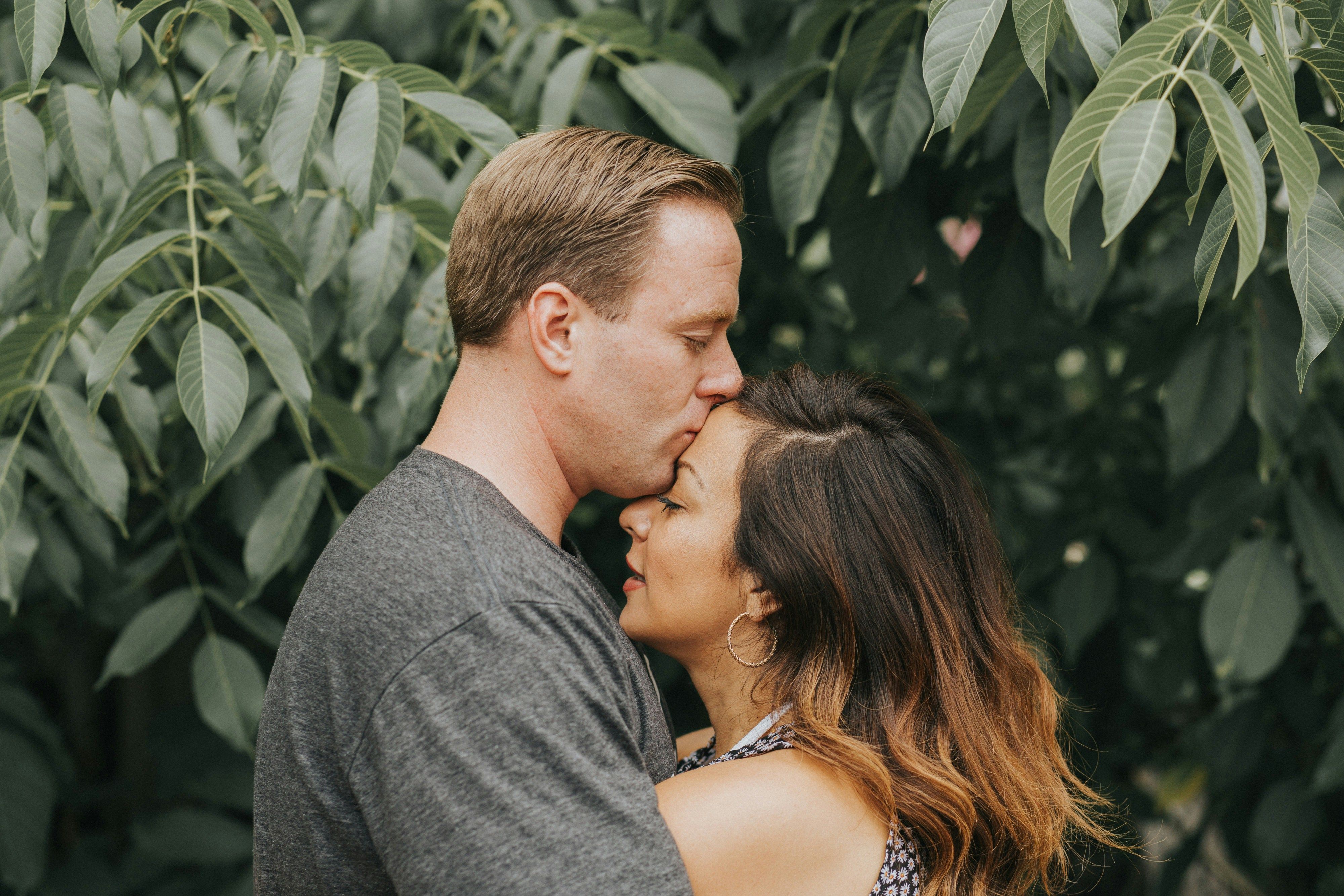 Couple hugging near tree leafs