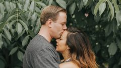 Couple hugging near tree leafs