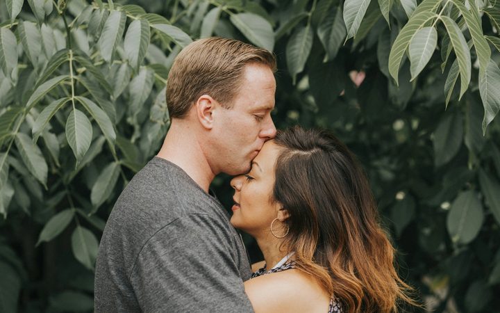 Couple hugging near tree leafs