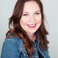 A slick headshot of Alma therapist Laura Brassie, smiling to the camera against a light gray backdrop.
