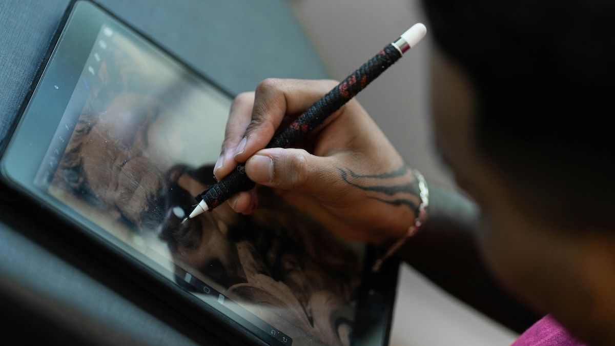 an art therapy client uses an iPad and stylus during an online session