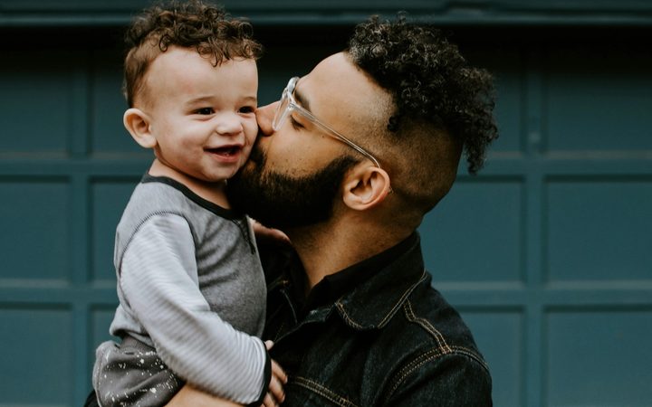 Father in jean shirt holding his baby boy with matching haircut