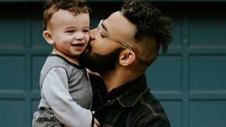 Father in jean shirt holding his baby boy with matching haircut