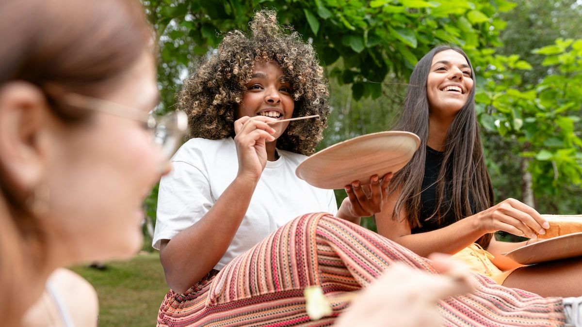 a woman eating with friends in the park