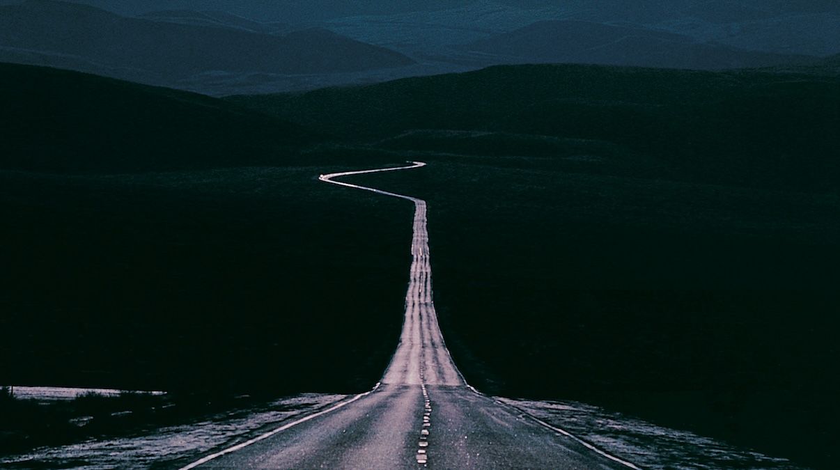 A highway stretching into the distance with a sharp curve visible on the horizon to represent anticipatory anxiety