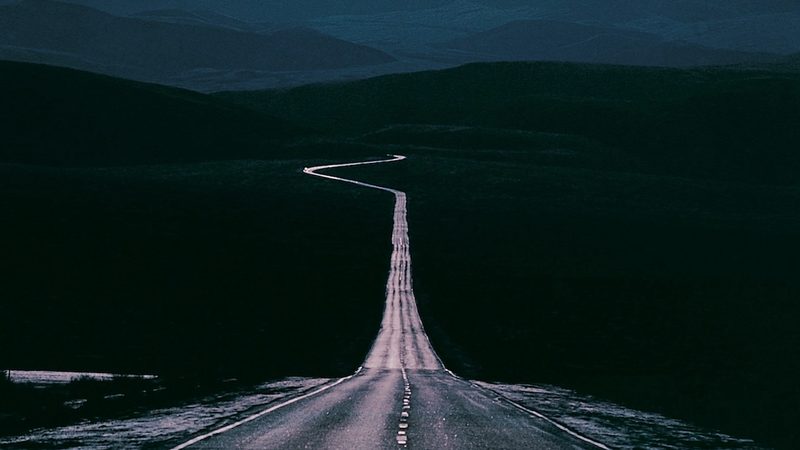 A highway stretching into the distance with a sharp curve visible on the horizon to represent anticipatory anxiety