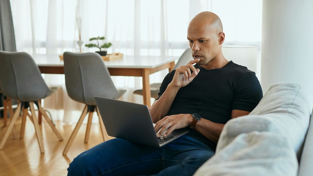 A man is at home on his laptop, learning about Optum's EAP