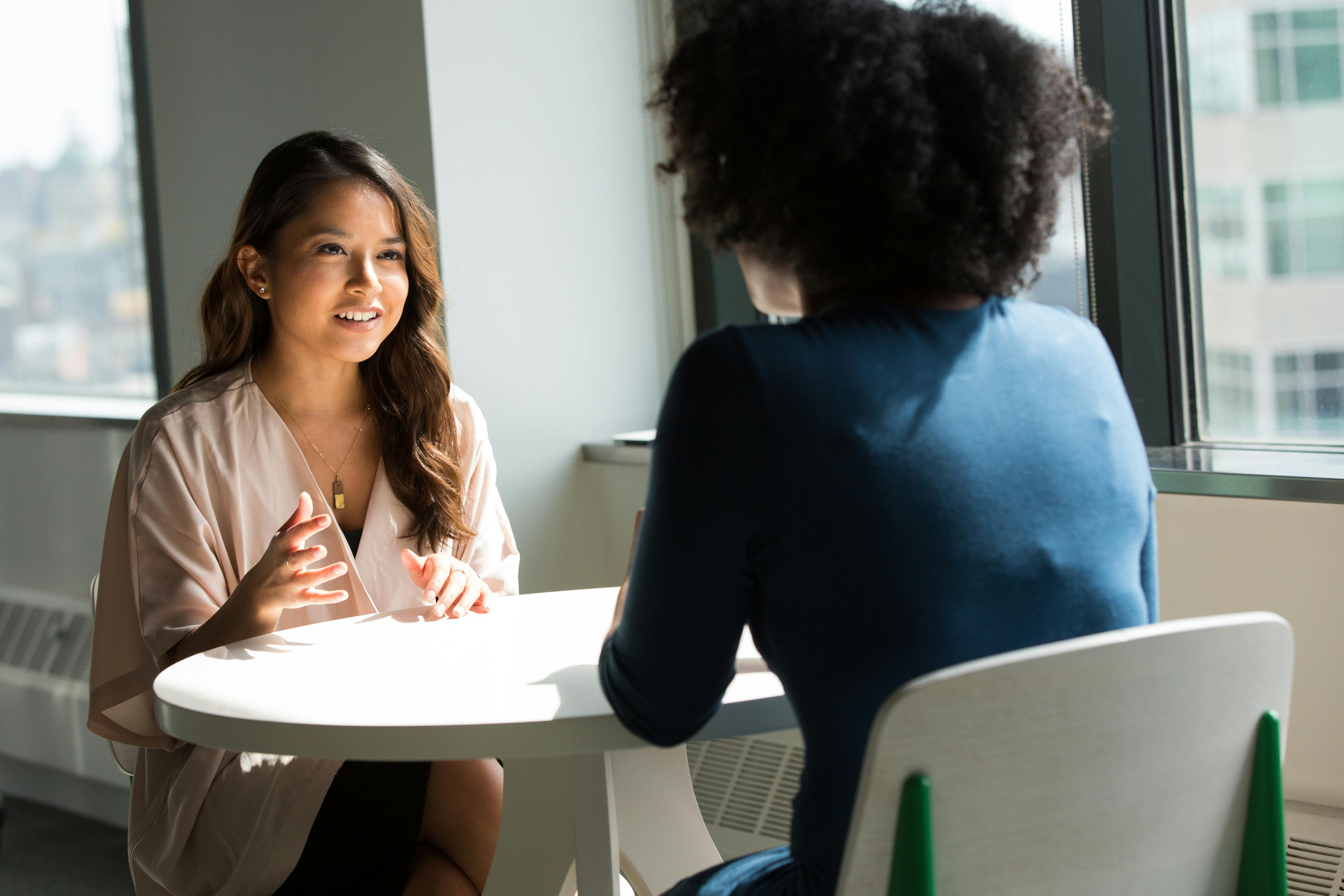 A young Asian American social work student speaks with her mentor.