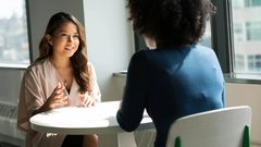 A young Asian American social work student speaks with her mentor.