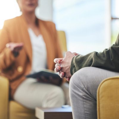 A clinician sits with their patient in a therapy session