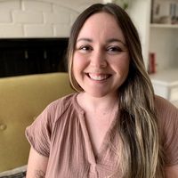 Lucy, a therapist with long brown hair, smiling from her well-designed home office.