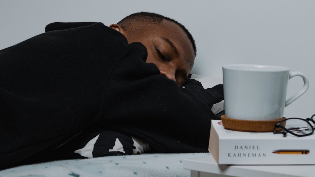 a young man slumps on his desk after losing an hour of sleep due to daylight saving time