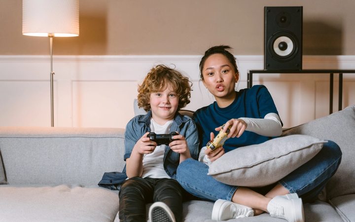 A therapist bonding a child she supports, playing a video game side-by-side.